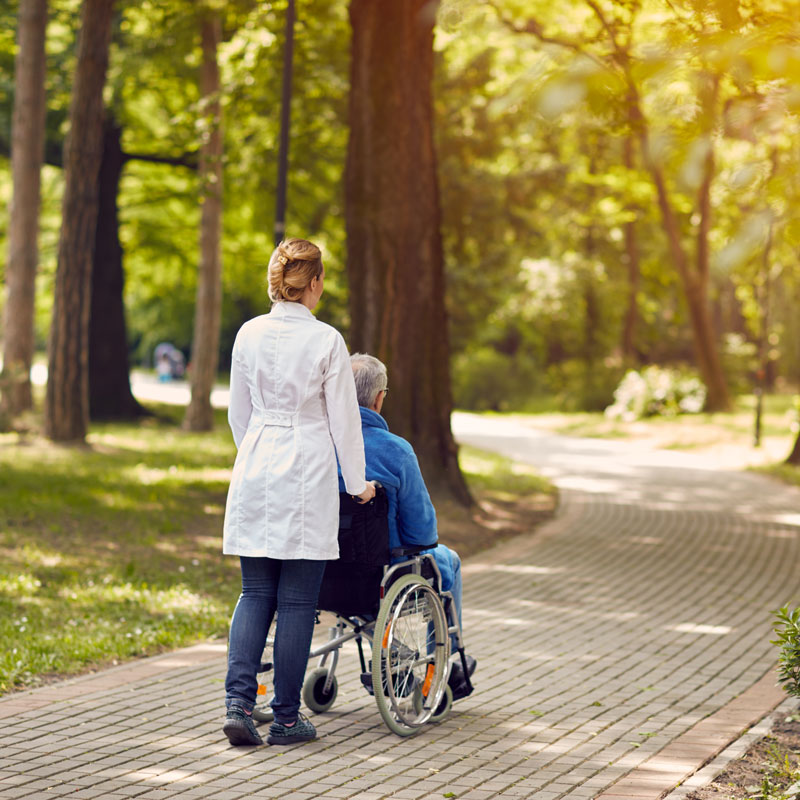 nurse pushing someone in wheel chair