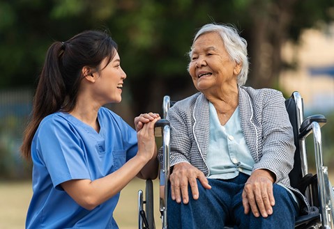 A Los Angeles nurse is outside with an elderly woman in a wheelchair