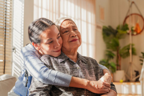 A lady hugs her mother, who is nearing the end of her life