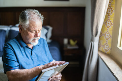 A man looks at a photo while grieving the loss of his spouse