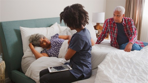 Caregiver holding patient’s hand during bedside support in Orange and LA Counties