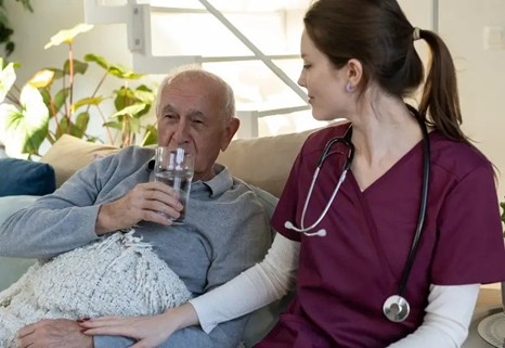 Nurse Assisting a patient in bed with family support in Orange and LA Counties