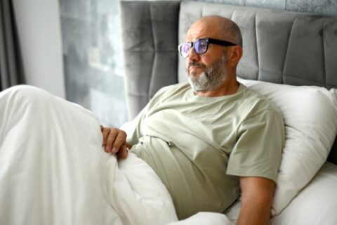 Patient sitting up in bed at home during hospice care in LA