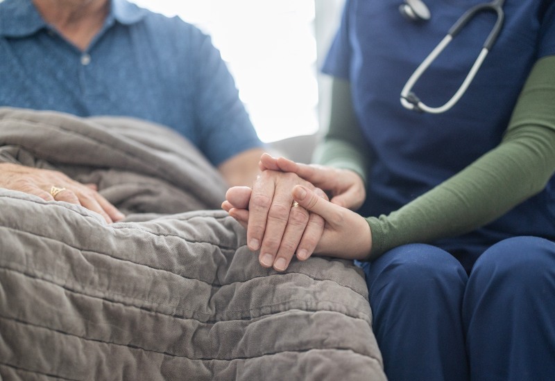 Hospice care provider holding a patient’s hand to offer support in Los Angeles & Orange Counties